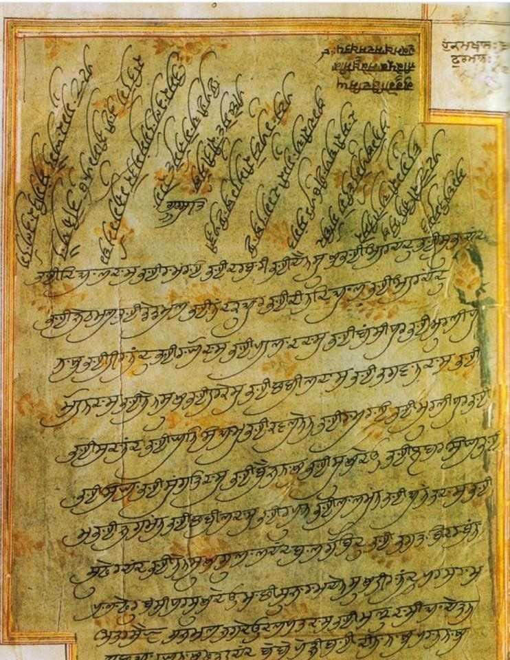 An illuminated historic Gurmukhi manuscript page with ornate floral borders
